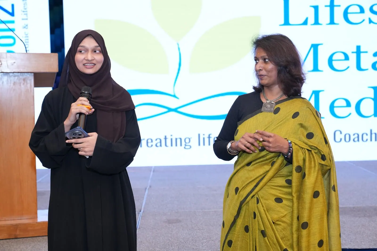 A coach with her award speaking at HolistiCon 2025
